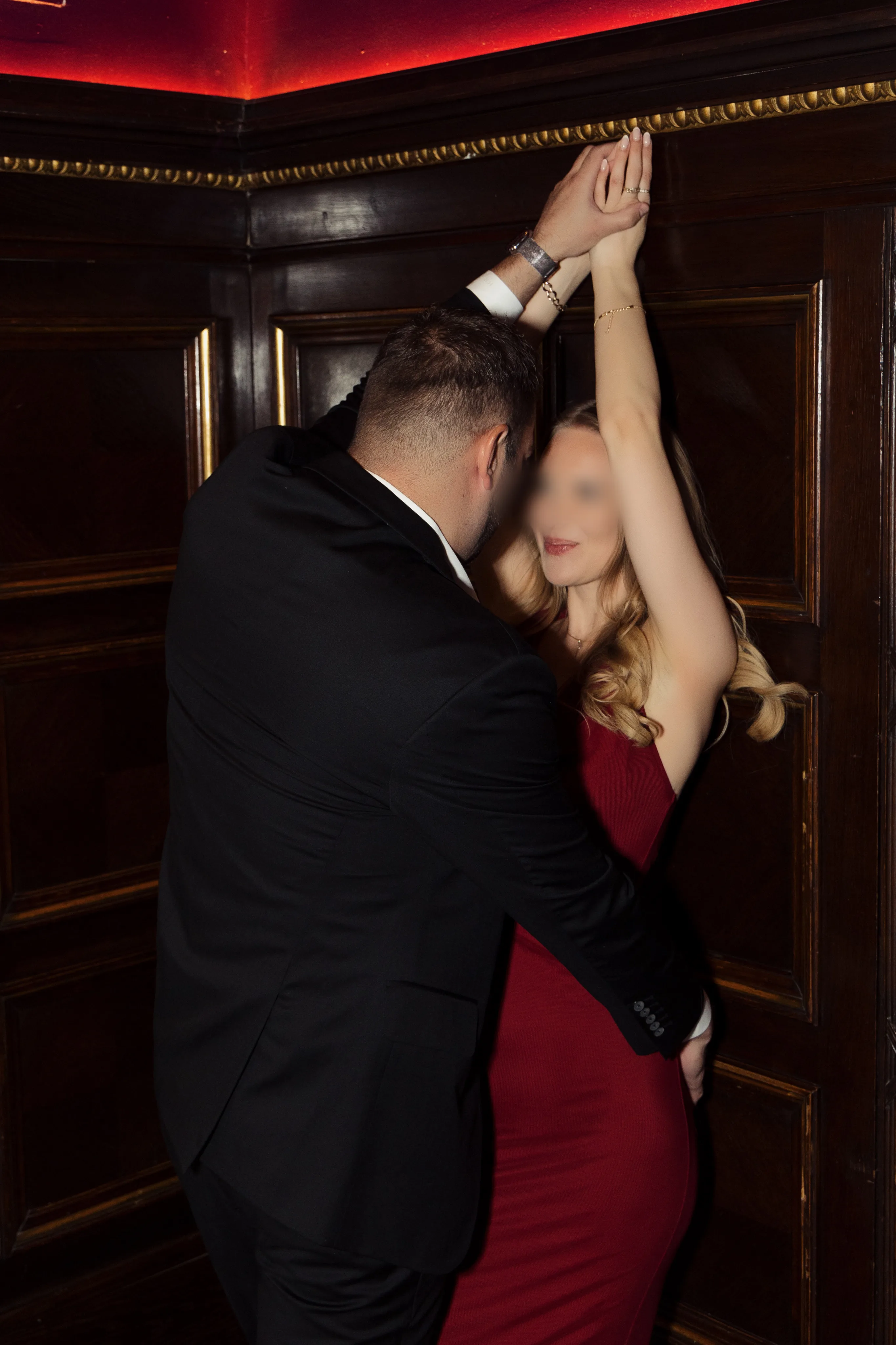 Stag and vixen intimate moment against dark paneling - hotwife lifestyle couple